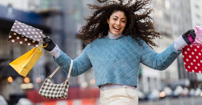 Eliminating Waste - Happy woman jumping with shopping bags