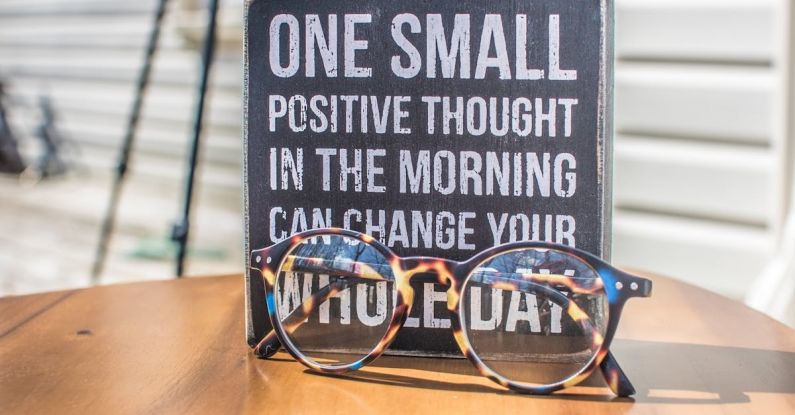 Inspirational Quotes - Photo of a Sign and Eyeglasses on Table
