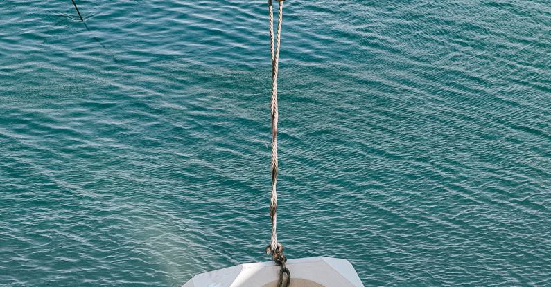 Deep Work - Faceless builders controlling crane on boat